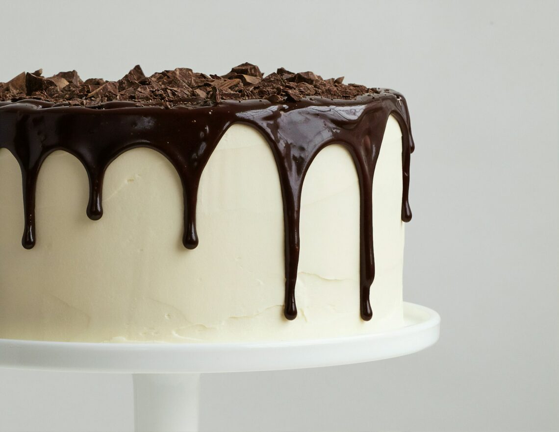 białe ciasto z syropem czekoladowym na białym talerzu ceramicznym