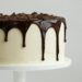 białe ciasto z syropem czekoladowym na białym talerzu ceramicznym